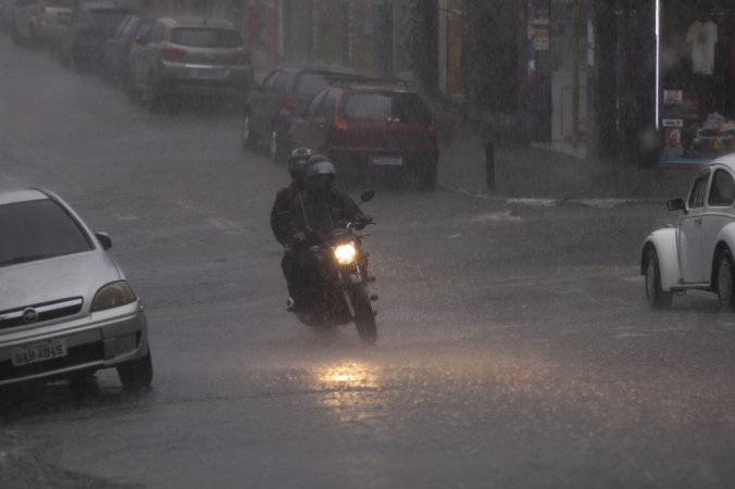 Moto passa por rua alagada em Guarulhos