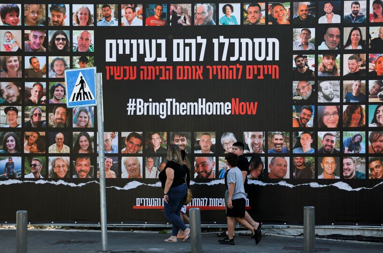 People walk past an installation which shows the pictures of hostages taken by Palestinian Islamist group Hamas following a deadly infiltration of Israel by Hamas gunmen from the Gaza Strip on October 7, before some of them are due to be released as part of a deal between Israel and Hamas to free hostages held in Gaza in exchange for the release of Palestinian prisoners, in Jerusalem, November 24, 2023 REUTERS/Ronen Zvulun
