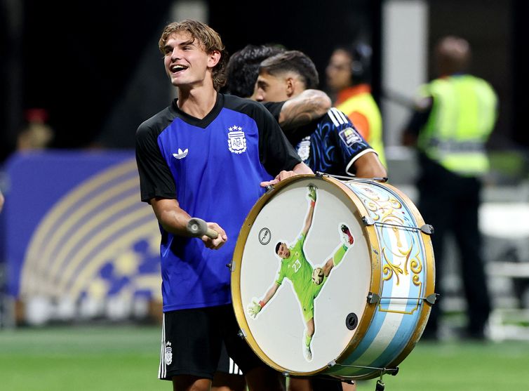 Reuters/Amanda Perobelli/Arquivo/Proibida reprodução Soccer Football - FIFA World Cup 2026 - Semi Final - England v Argentina - Atlanta Stadium, Atlanta, Georgia, U.S. - July 15, 2026 Argentina's Nico Paz celebrates with a Emiliano Martinez themed drum after the match as Argentina qualify for the final of the World Cup REUTERS/Amanda Perobelli